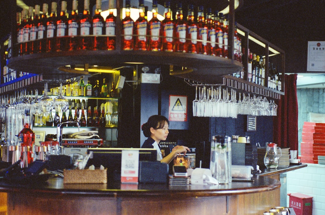 bartender-working-behind-a-bar-with-bottles-fphwokt16ku