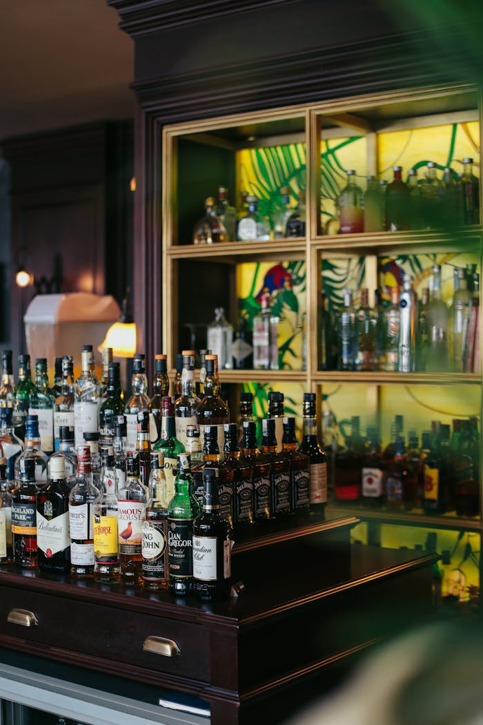 Sophisticated bar setup displaying an array of whiskey bottles with ambient lighting.