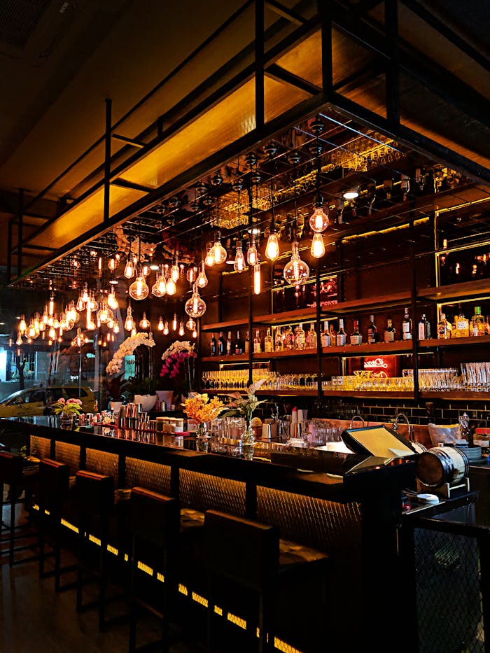 Contemporary bar with warm lighting, showcasing a chic interior with stocked shelves and stylish decor.