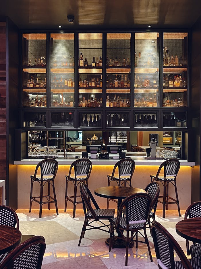 Luxurious bar setting with stocked shelves and bar stools, ideal for leisure.